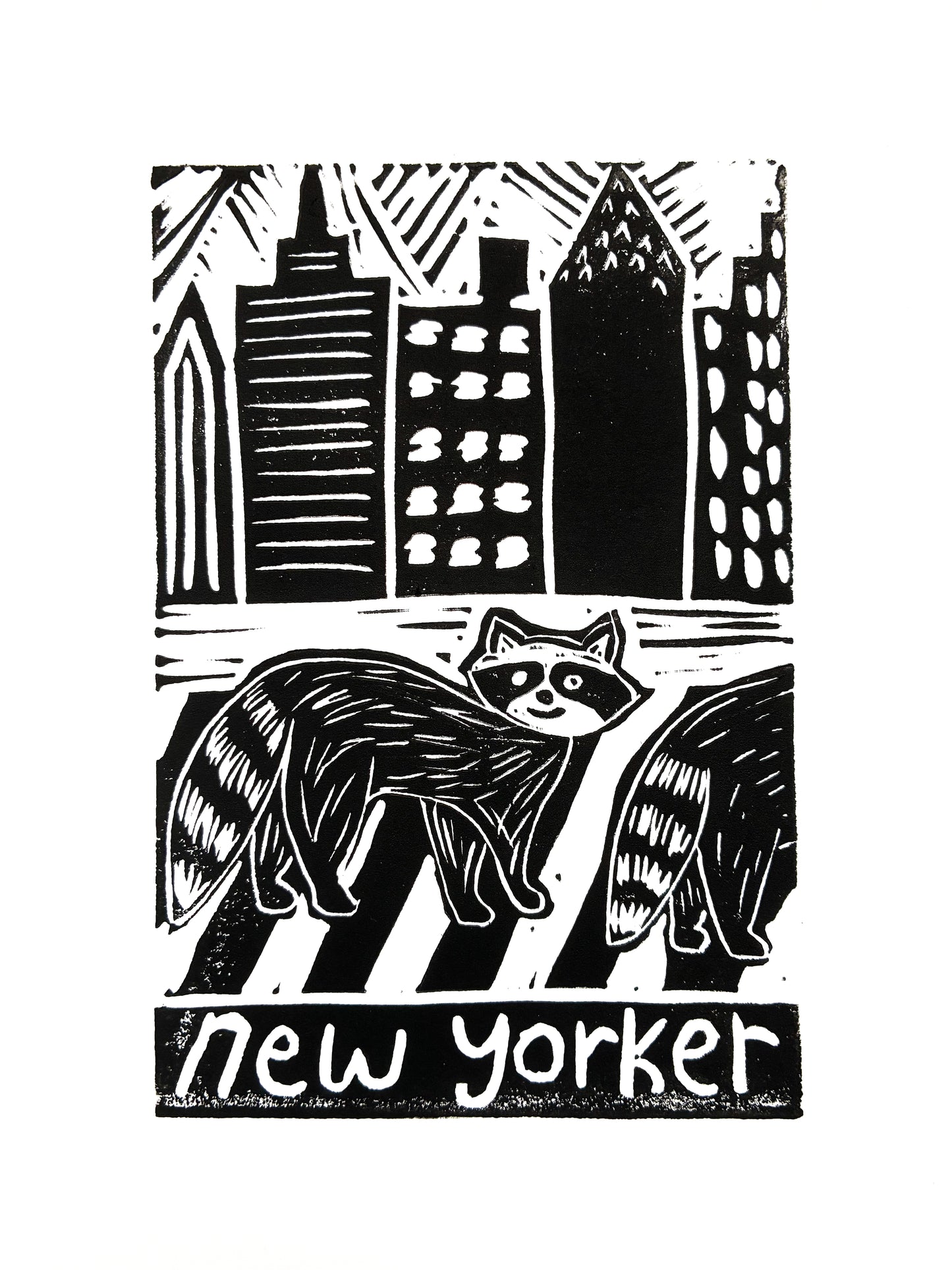 Print of two raccoons crossing a street with city skyline in the background, with 'new yorker' text.