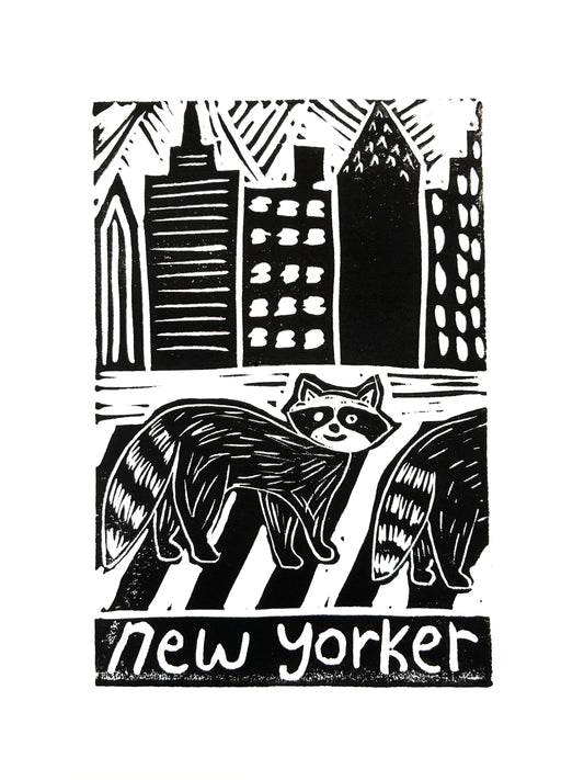 Print of two raccoons crossing a street with city skyline in the background, with 'new yorker' text.