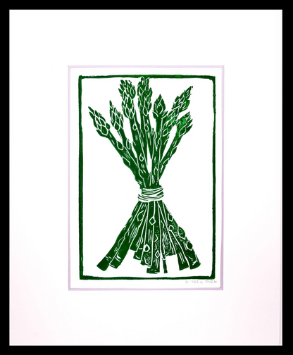 A minimalist art print featuring a dark green linocut-style illustration of a tied bundle of asparagus on a white background, framed by a thin double border and a black outer edge.