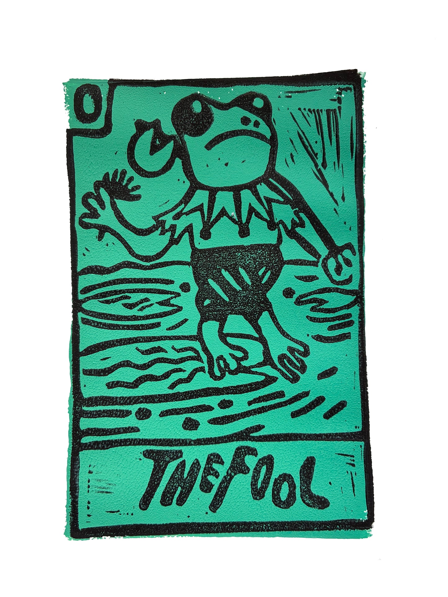 Green and black Tarot card print with a stylized frog dressed as a jester and 'The Fool' text.