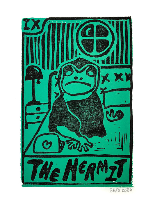 A square art print featuring a stylized black ink illustration of a hermit frog on a bright green background, with the text 'THE HERMIT' at the bottom and an artist signature 'SOU 2026' in the lower right corner.