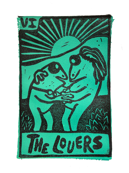 Green and black Tarot card print with two stylized frogs dancing and 'The Lovers' text on a green background.
